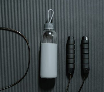 بطری آب و طناب ورزشی روی مت